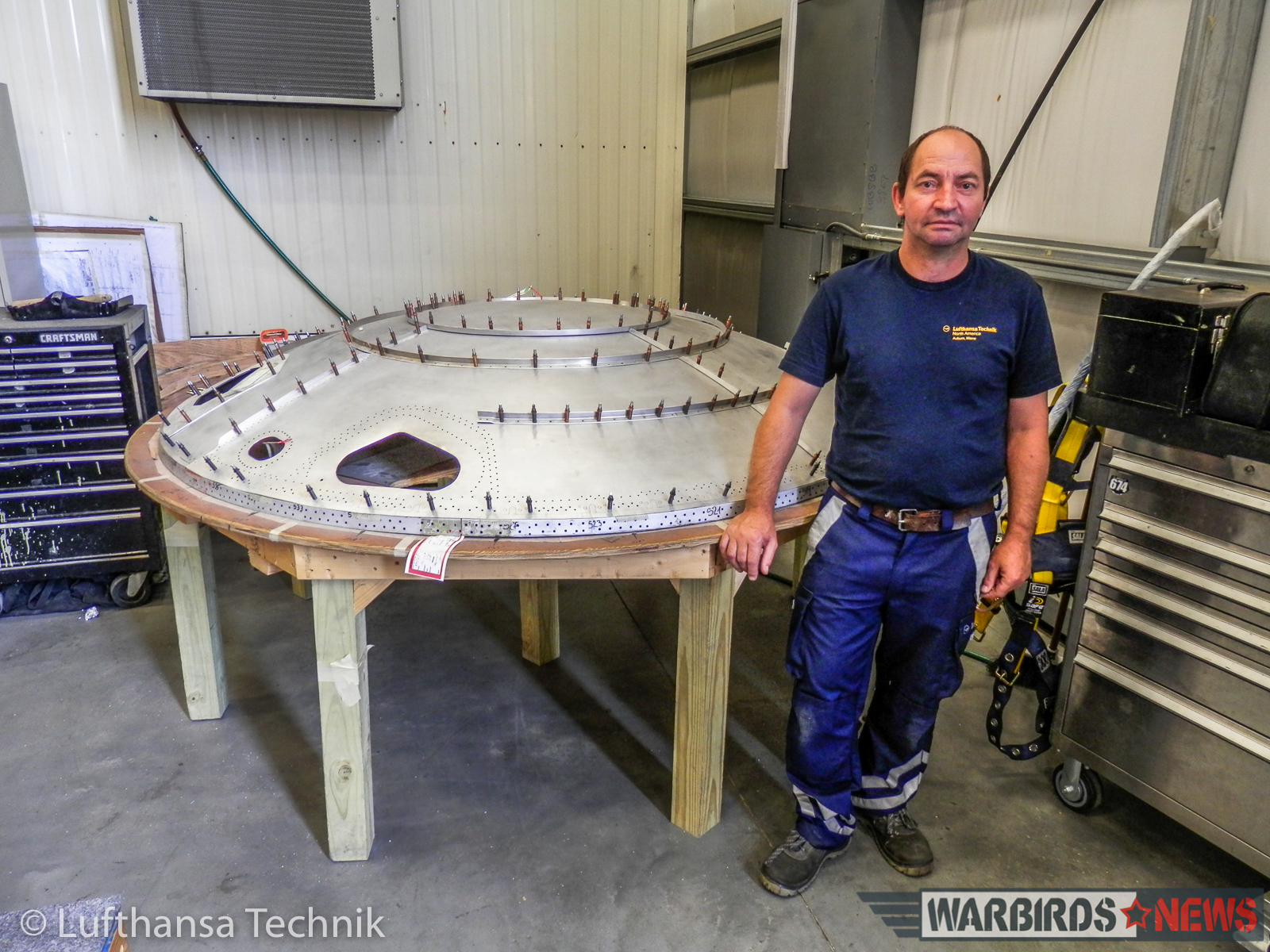 Master sheet metal specialist, Gyula Nagy of Lufthansa Technik Budapest standing in front of the rear fuselage pressure bulkhead he remanufactured in Lewiston, Maine. (© Lufthansa Technik)
