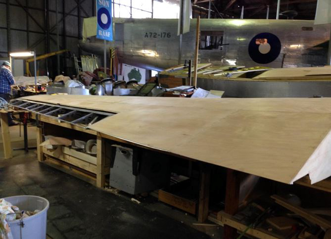 The left wing nearing completion. RAAF Liberator A72-176 can be seen in the background. (photo via B-24 Liberator Memorial Fund)