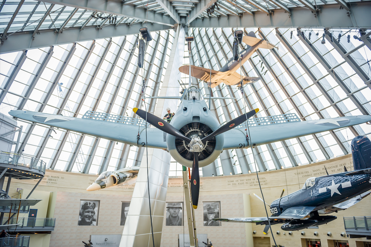 An SBD-3 (Scout Bomber Douglas) Dauntless, is weight tested, lifted and installed as part of the World War II exhibit at the National Museum of the Marine Corps, Triangle, Va., Feb. 9, 2016. This fully restored, donated aircraft has been painted to represent the SBD-3 flown by Maj. Richard C. Mangram and Cpl. Dennis E. Byrd during the Guadalcanal Campaign on Aug. 25, 1942. (Official United States Marine Corps photo by Kathy Reesey/Released)