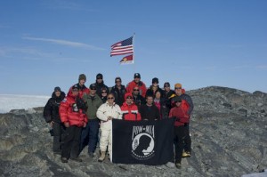 An expedition team of U.S. Coast Guard service members and North South Polar, Inc. scientists and explorers display the POW/MIA flag in honor of the expedition to find the crash site of a WWII Coast Guard Grumman Duck. (Photo credit: USCG)