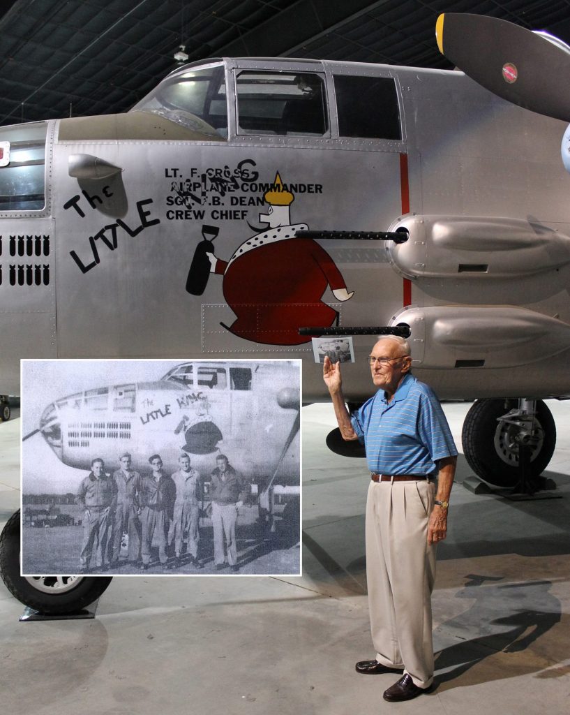 Tail Gunner Norris holds a copy of a photo that shows his crew standing by the original “The Little King.” In that photo (see inset), Norris is the second from the right. (Image Credit: Museum of Aviation)