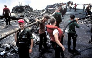 Crewmen battle the remnants of the blaze that literally burned the F-4B Phantoms in the background to the ground (Image Credit: US Navy)