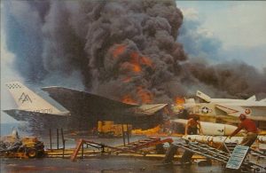 Fire aboard the US Navy aircraft carrier USS Forrestal (CVA-59) on July 29, 1967. Two North American RA-5C Vigilantes  burn on the starboard side aft of the island, while crewmen remove AGM-45 Shrike missiles in the foreground. (Image Credit: US Navy)
