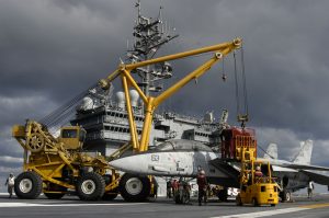 Crash-and-salvage personnel rig a training skeleton of an F-14 Tomcat to a mobile crane used to move damaged aircraft off the flight line during crash and salvage operations aboard the USS Kitty Hawk (CV 63) (Image Credit: US Navy)