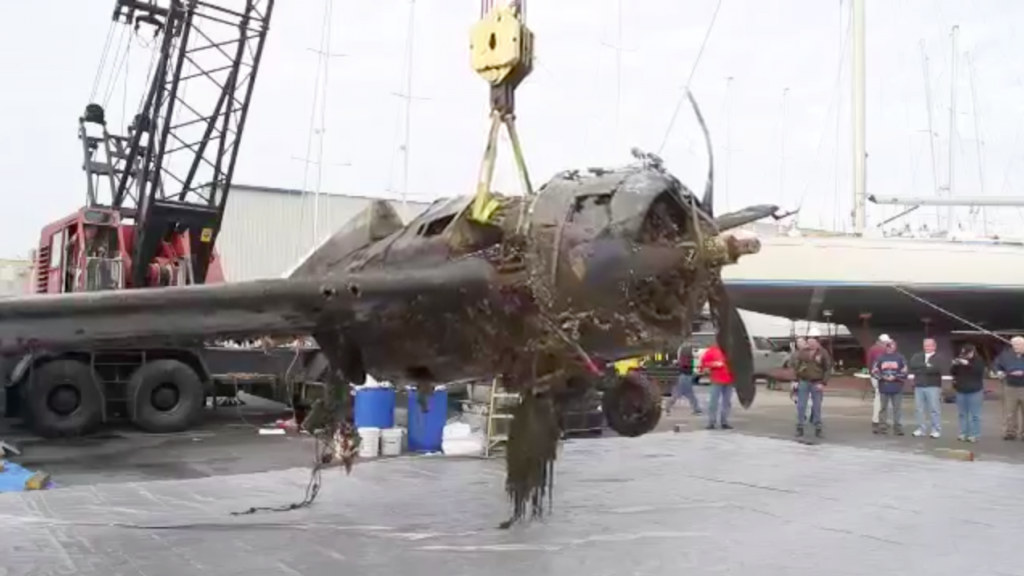 Wildcat FM-2 57039, Lifted from the water, heading to Air Zoo for a full restoration 