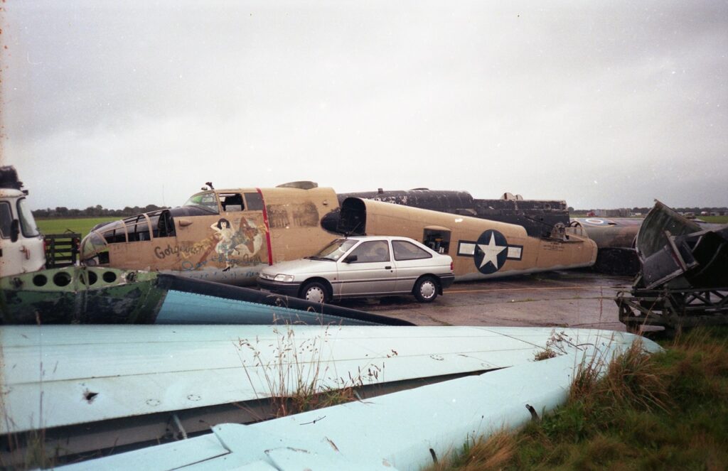 The B-25 derelict in open storage at Sandtoft in the UK in 1999, showing the toll taken on the aircraft's multiple layers of theatrical paint by the British weather. [Photo by Nigel Hitchman]