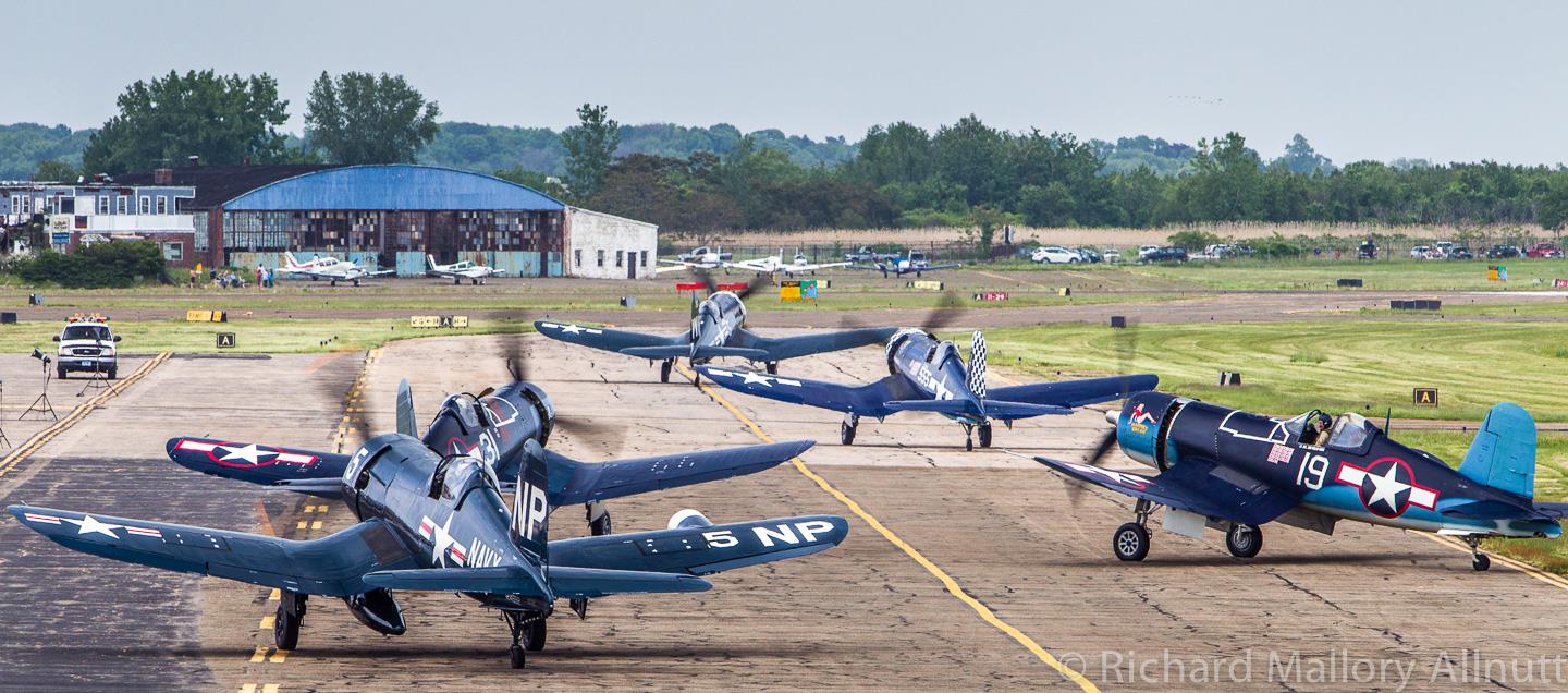 Corsairs taxiing during Corsairs Over Connecticut in 2010. The Curtiss Hangar is clearly visible in the distance. This scene is very reminiscent of similar images from the heyday of Corsair production during WWII. (photo by Richard Mallory Allnutt)