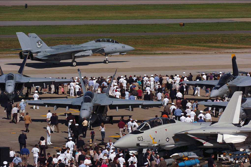 A crowd gathers to bid farewell to a U.S. Navy F 14 Tomcat aircraft while it taxis down the runway during its final flight ceremony at Naval Air Station Oceana Va. on Sept. 22 2006