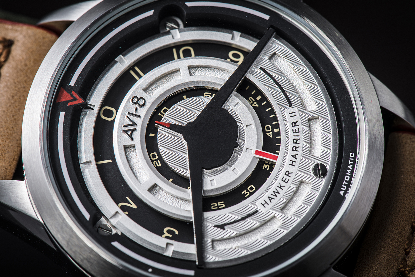 A close-up view of the watch dial clearly shows the Harrier silhouette in black on the front, and how it subtly indicates the time with the rotating discs displaying the hour, minute and second.