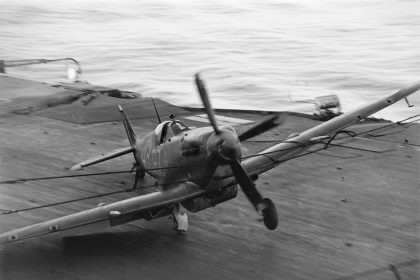 A Supermarine Seafire hits the barrier on HMS INDEFATIGABLE after returning from a strike on the Japanese oil refinery at Pangkalan Brandan Sumatra 1 April 1945. A27176