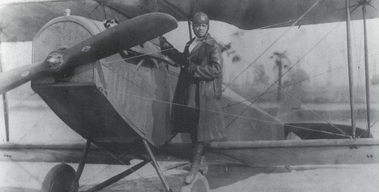 Bessie Coleman standing on the wheel of a Curtiss JN-4 "Jenny". [Photo Public Domain]
