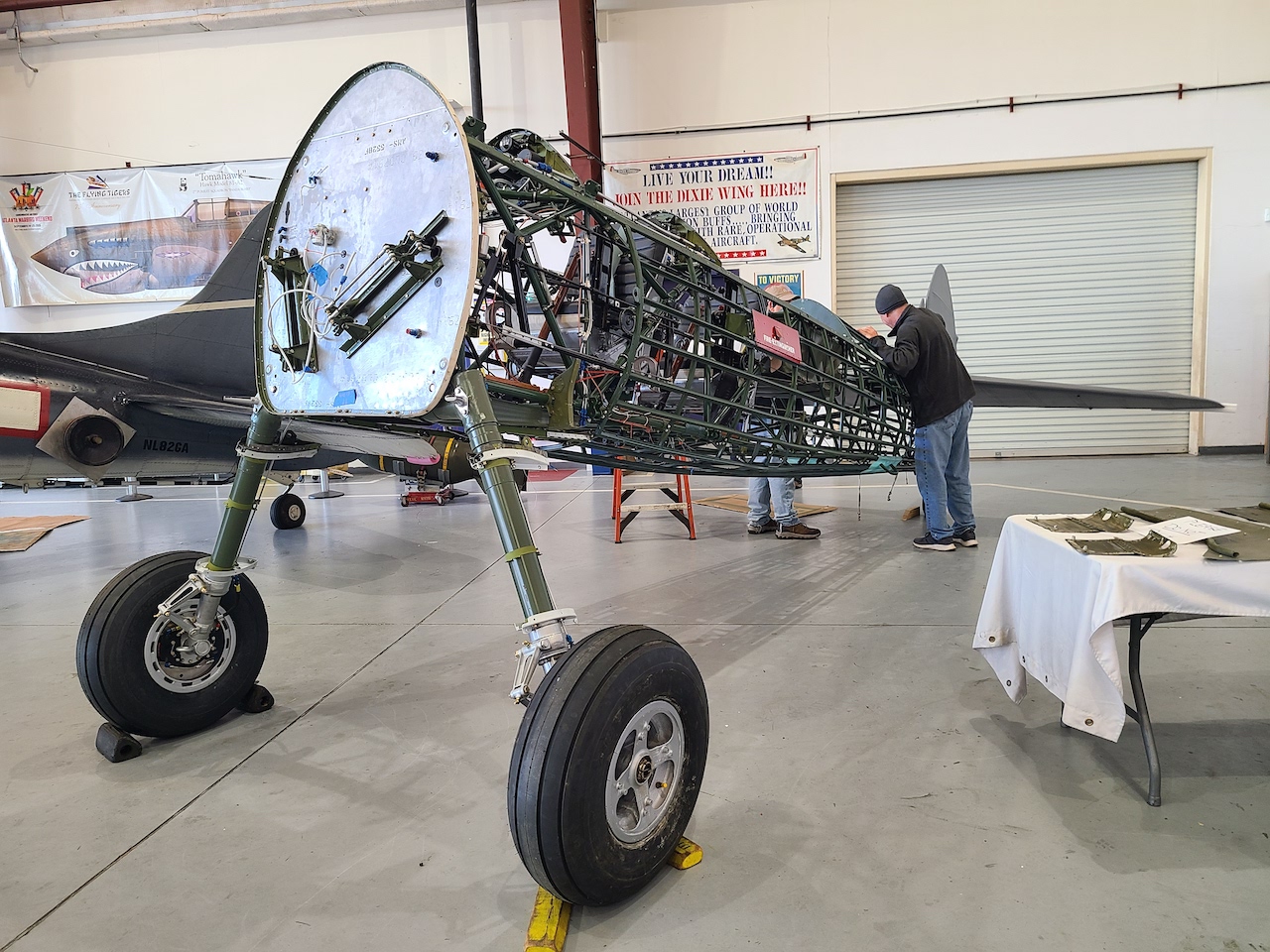 The Stearman for the first time sees the light of the CAF Airbase Georgia's hangar. You can see the tail of the unit's SBD-5 Dauntless. [Photo by Angela Decker]