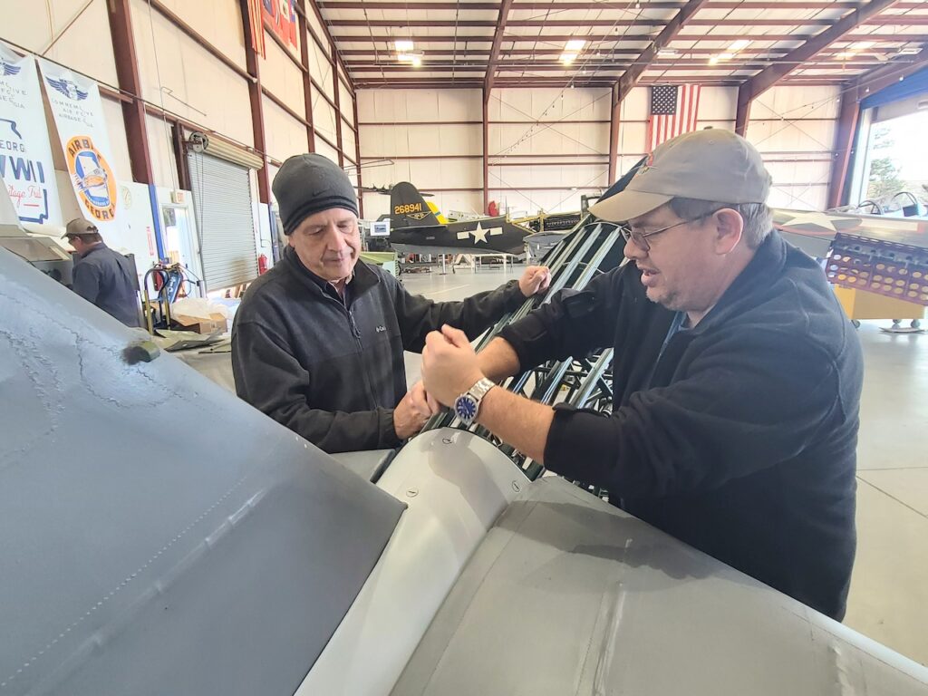 Volunteers Brad Postage (left) and Michael Lamble working on the tail fairing of the Stearman. [Photo by Angela Decker]