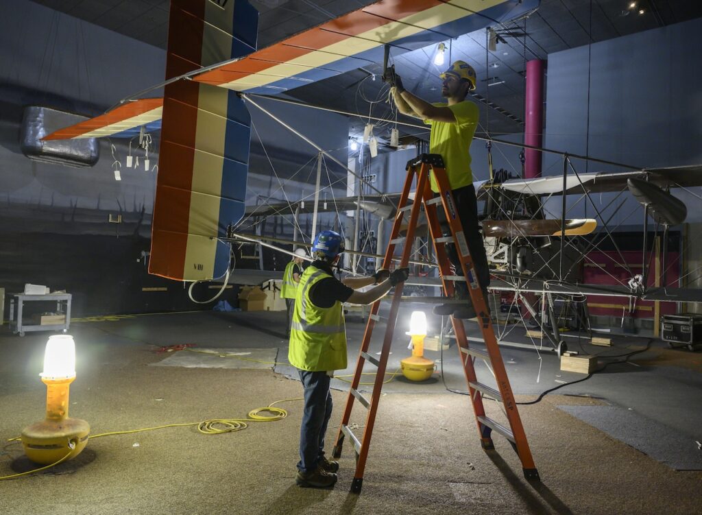 Contractors disconnect wires and disassemble the Voisin Type 8 aircraft in the WWI gallery June 13 2019. Smithsonian photo by Jim Preston