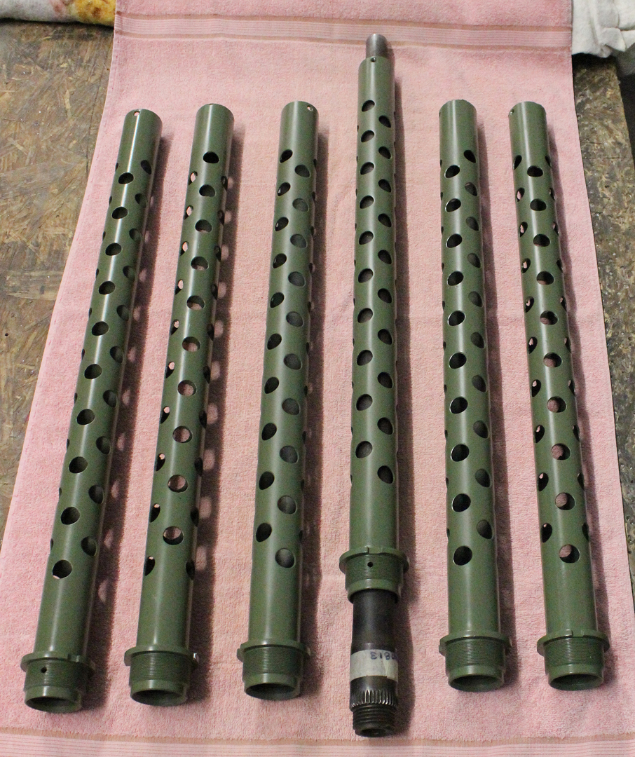 The cooling jackets for the six machine guns. Note the fourth example from left shows the rear end of a gun barrel demonstrating how it slides into position. (photo via Tom Reilly)