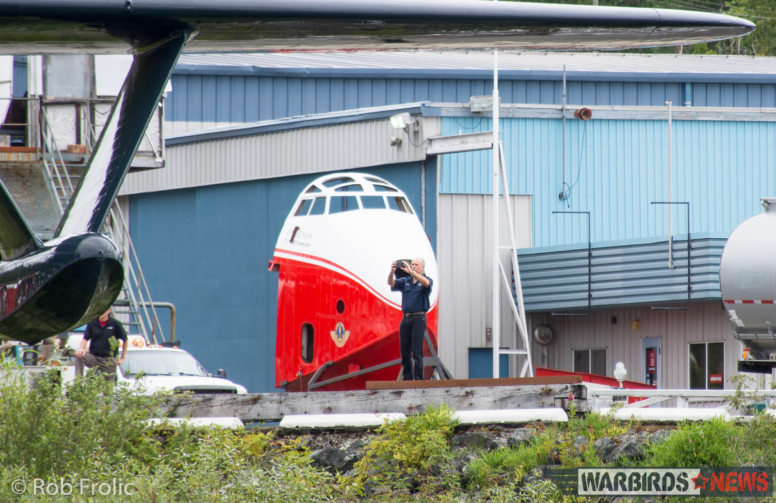 Kermit Weeks filming Philippine Mars going into the waters at Sproat Lake. A spare forward fuselage is seen in the background. (photo by Rob Frolic)