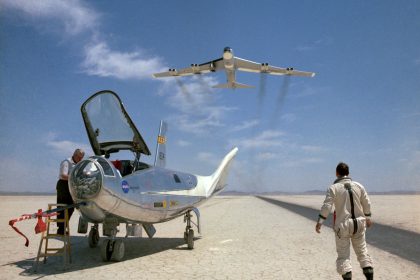 NASA research pilot Bill Dana takes a moment to watch NASA's NB-52B cruise overhead after a research flight in the HL-10.