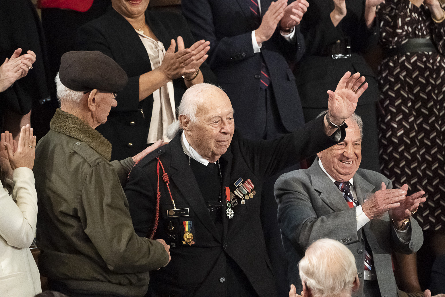 Holocaust survivor Joshua Kaufman left applauds World War II D Day Veteran Herman Zeitchik joined by fellow D Day veterans Irving Locker Official White