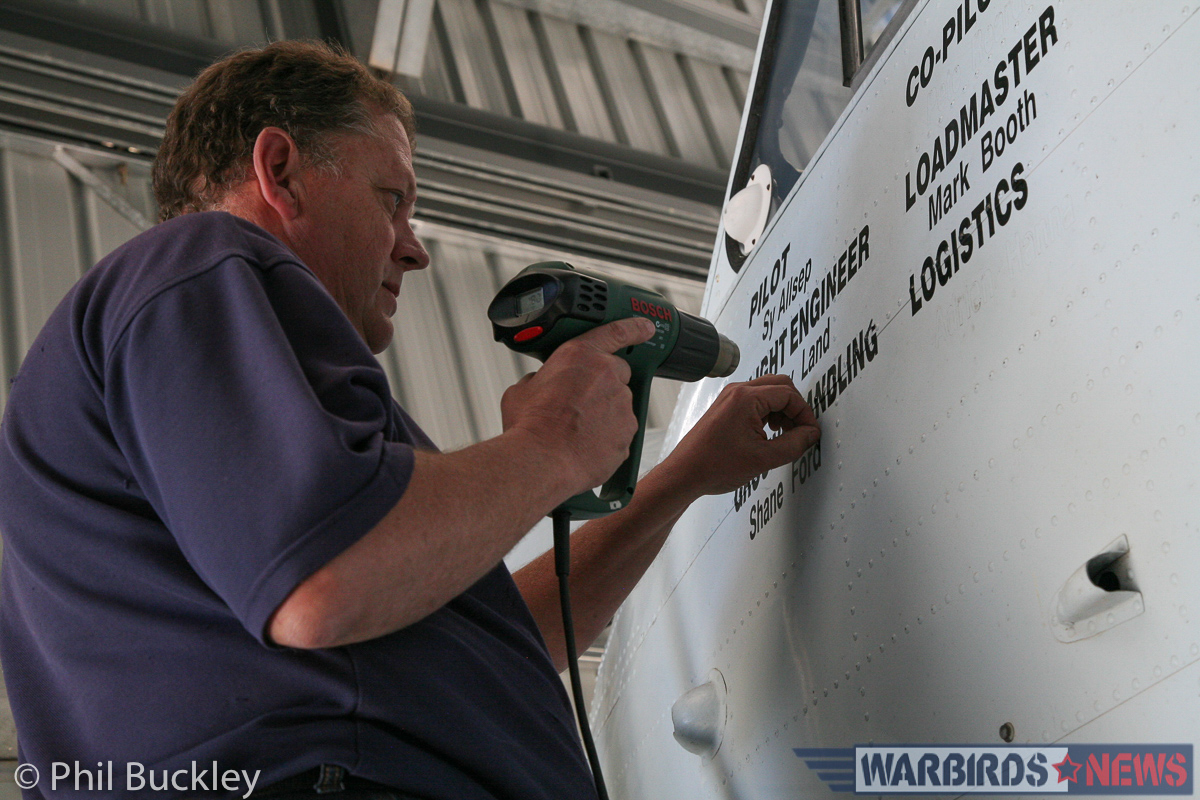 Richard Thompson using a heat gun to remove the old aircrew stenciling from the cockpit side. (photo by Phil Buckley)