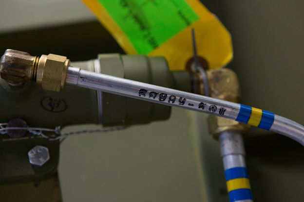 The hydraulic line that leads from the manual emergency hydraulic pump. Note the perfectly replicated color coding and part number on the tubing. (photo via AirCorps Aviation)