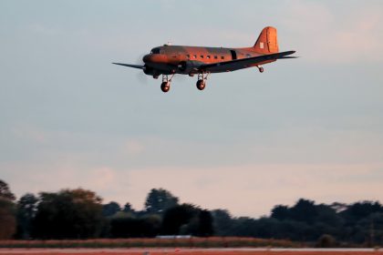 Lit by the early evening setting sun BBMF Dakota ZA947 makes an approach to land at RAF Coningsby on 29th August 2025 after over three years away. Photo Kiran Lear via BBMF