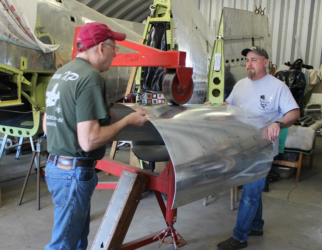 Paul and Randall hand forming the nose cowling skins using an English Wheel. (photo via Tom Reilly)