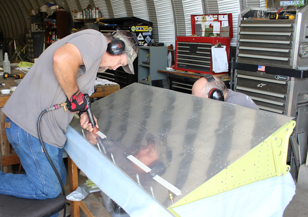 Paul and Randall riveting the outer skins to one of the flaps. (photo via Tom Reilly)