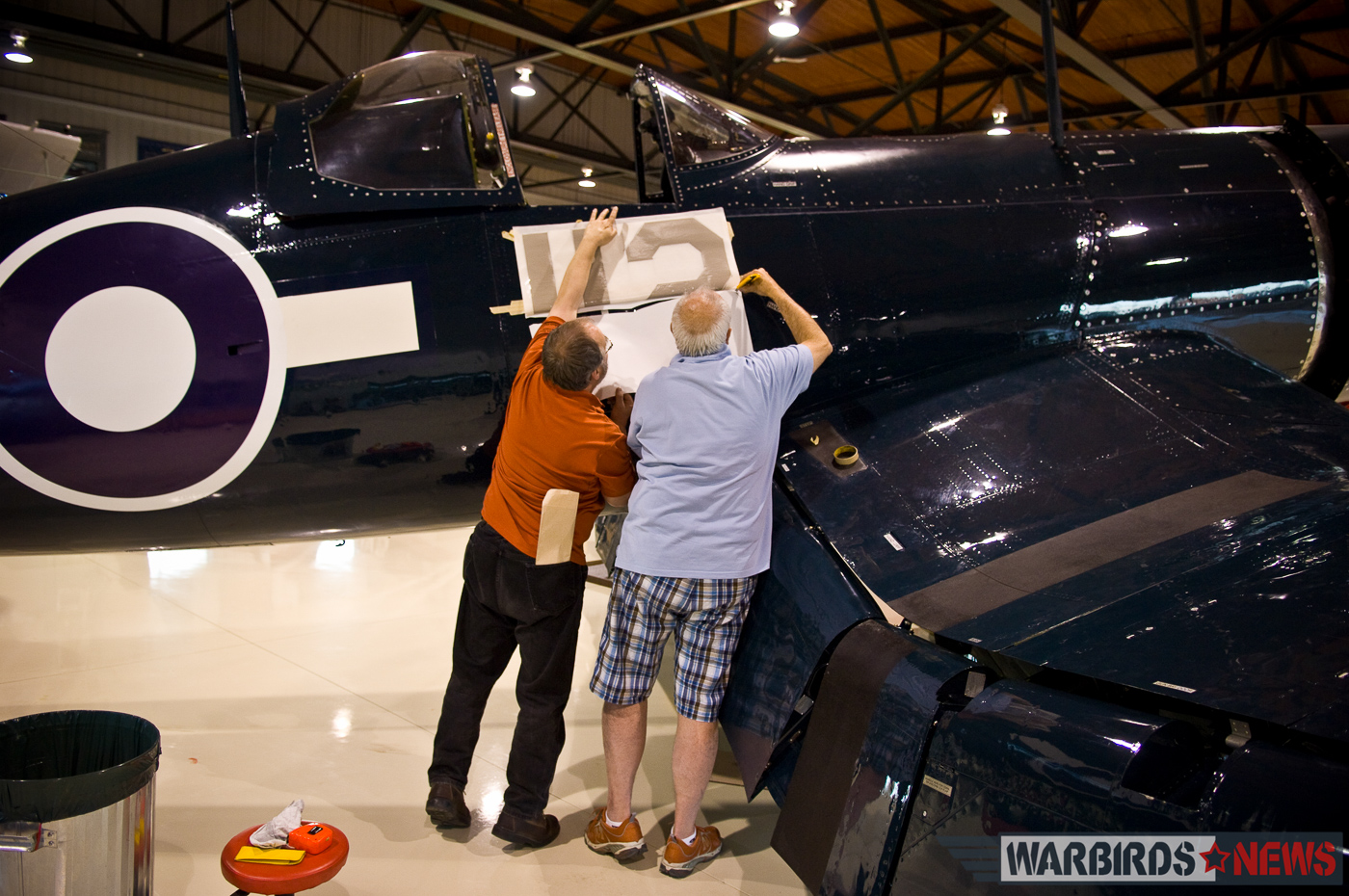 Dave O'Malley (right) and a colleague applying the decals to transform FG-1D Bu.92106 into Robert Hampton Gray's Corsair IV. (photo by Peter Handley)
