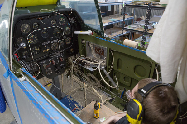  Aaron is looking over the job ahead of him. The yellow object in front of Aaron is a heat gun. (photo via AirCorps Aviation)