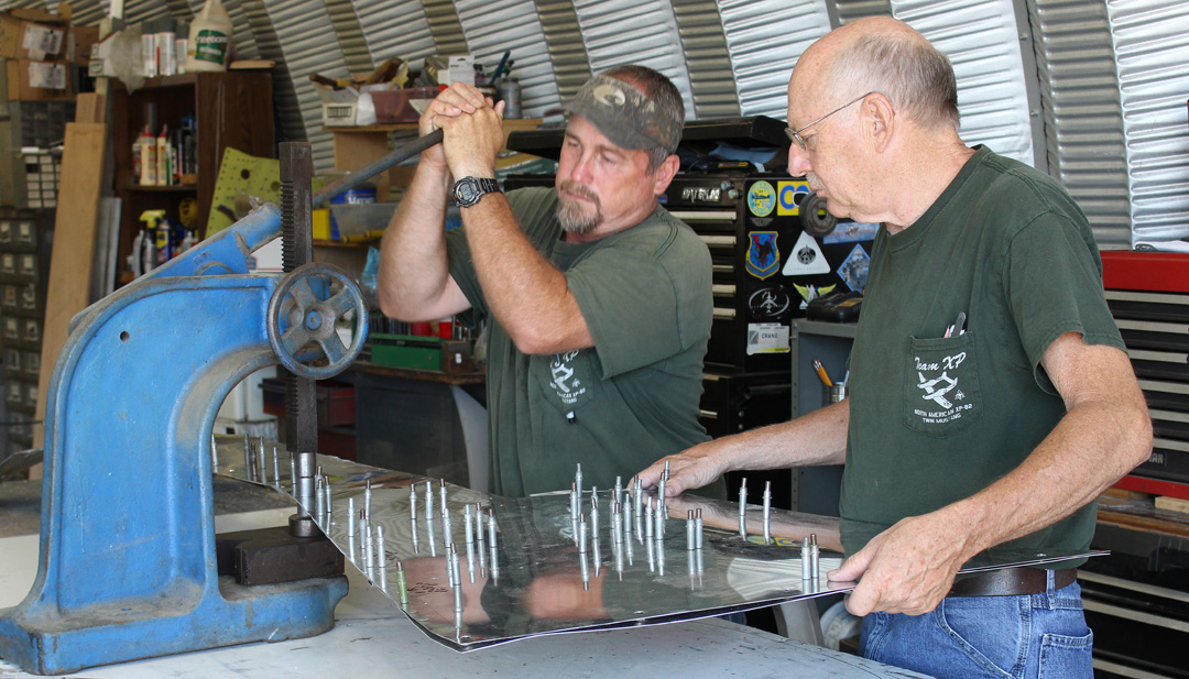 Randall & Paul press-dimpling the cowling side skins for the Dzus fasteners. (photo via Tom Reilly)