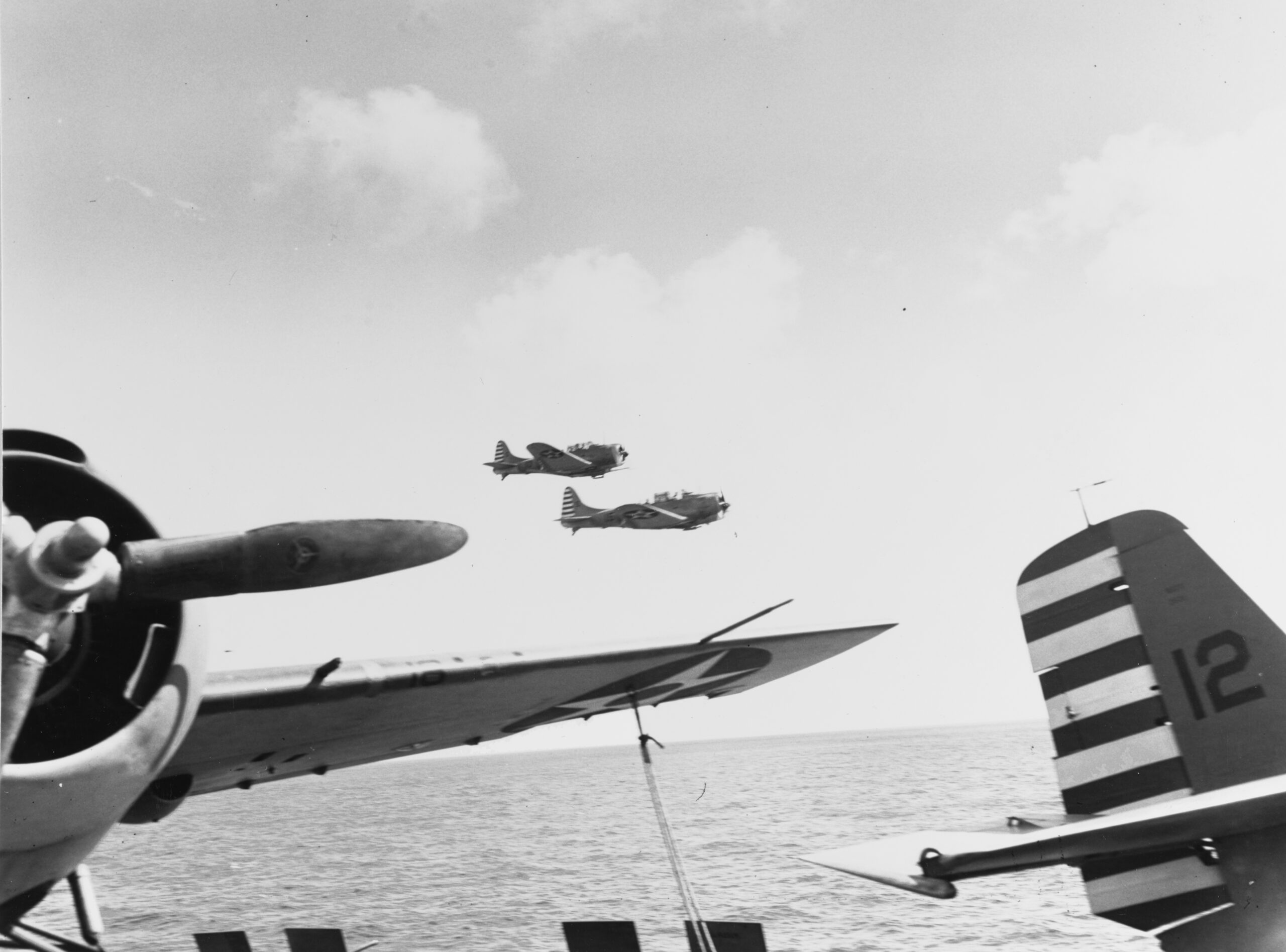 A brace of SBD-3s from VS-5 flying past USS Yorktown (CV 5) during April, 1942. (U.S. Navy photo)