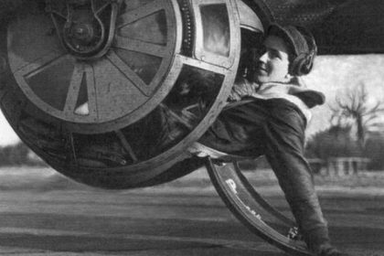S Sgt. Alan E. Magee poses for the camera halfway into the tight confines of the ball turret of a B 17 Flying Fortress