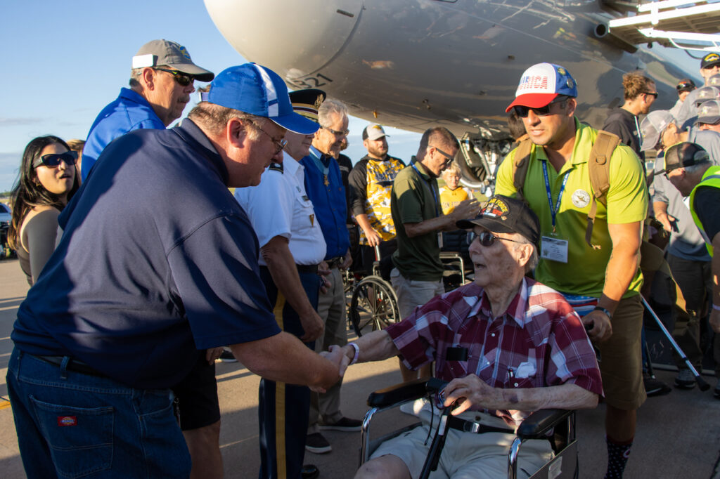 Missions of Honor Yellow Ribbon Honor Flight Returns to EAA AirVenture Oshkosh 2026 12 Sean Elliott welcomes vet Honor Flight 23 by Bailey Noel