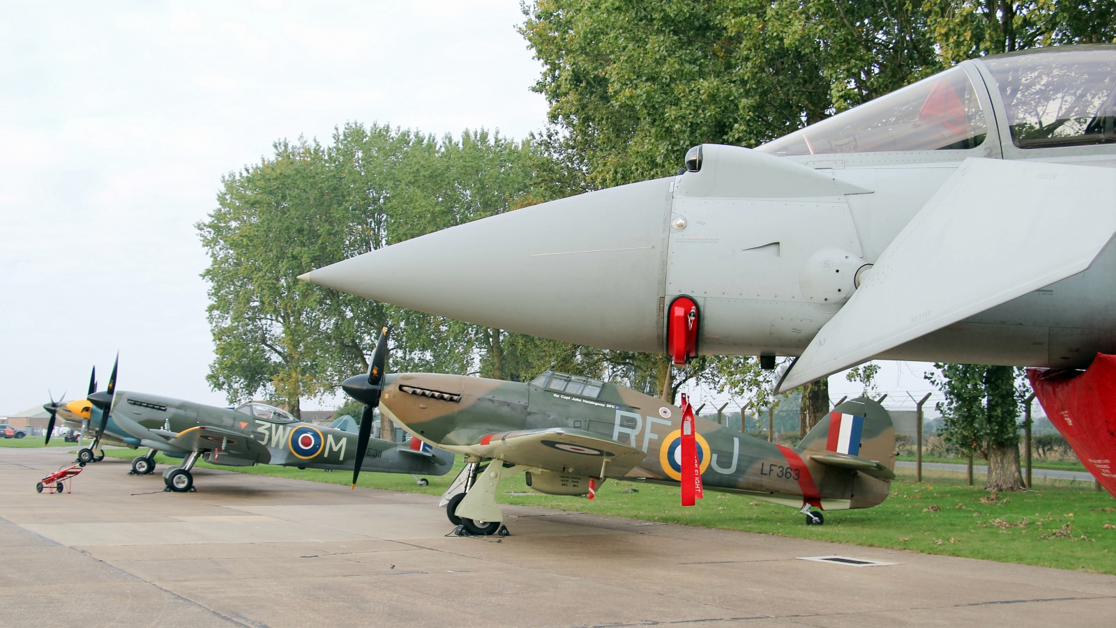 Static line up of BBMF fighters under the nose of a Typhoon FGR4. Photo Clive Rowley