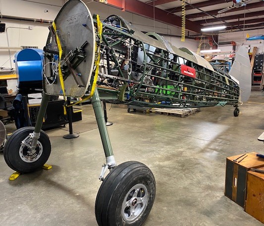The WWII Stearman biplane trainer being restored at Commemorative Air Force Airbase Georgia in Peachtree City, Ga., now has "feet" and a tail, and has graduated from the shop to the hangar. The CAF 12 Planes of Christmas annual fundraising campaign brought in $15,185 to help purchase an avionics package. (Photo by Angela Decker)