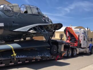 Strapped to a flatbed trailer towed by Polar King International TBM Avenger 91188 arrives at the Castle Air Museum restoration hangar Castle Air Museum