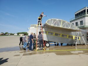 Students of EHOVE Adult Career Center wash down the Ford s fuselage in preparation for painting May 2023 THF s Port Clinton Ford Tri Motor Restoration