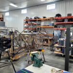 The fuselage frame and engine at the AirCorps Aviation hangar