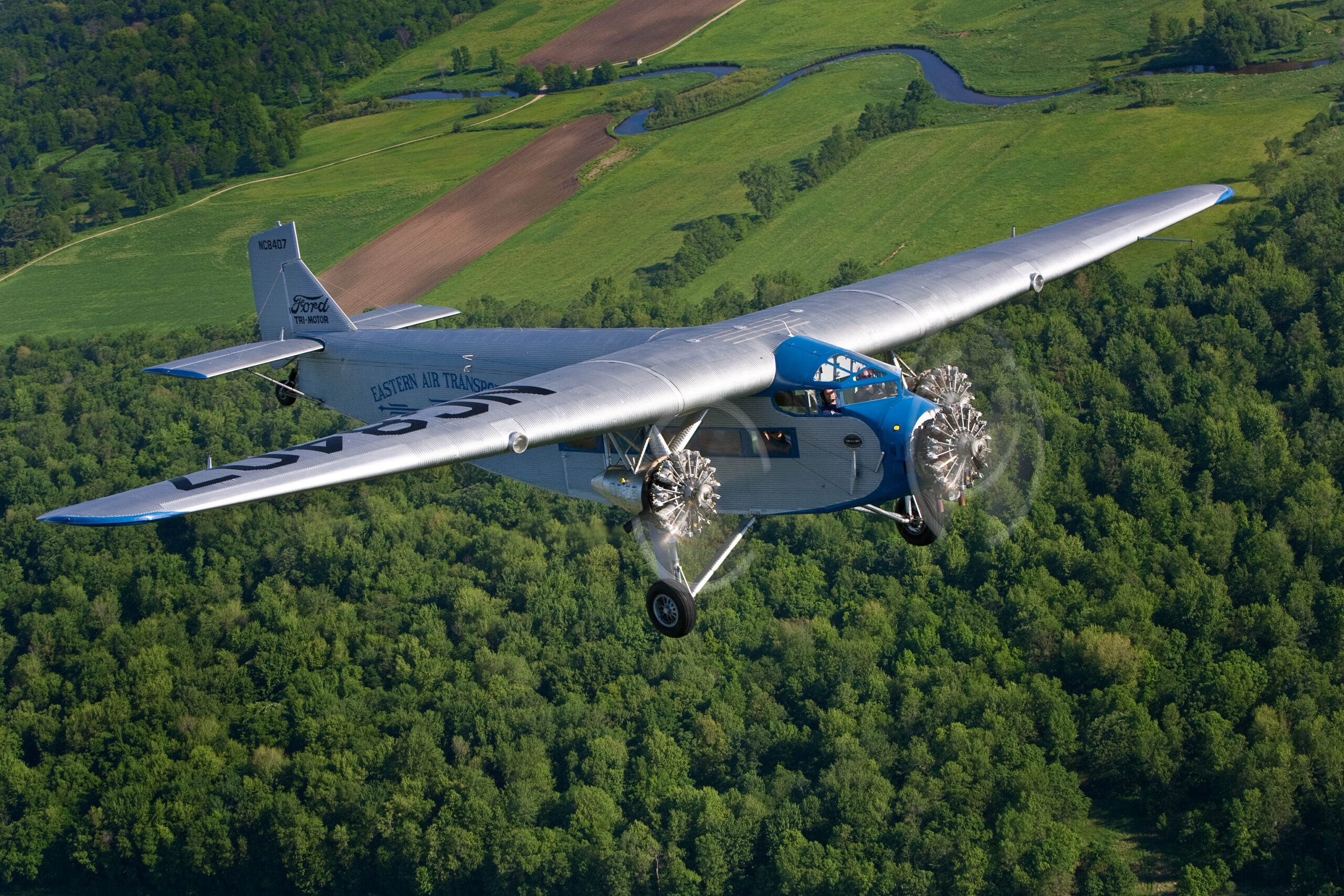 Tri Motor over woods by Jim Koepnick scaled