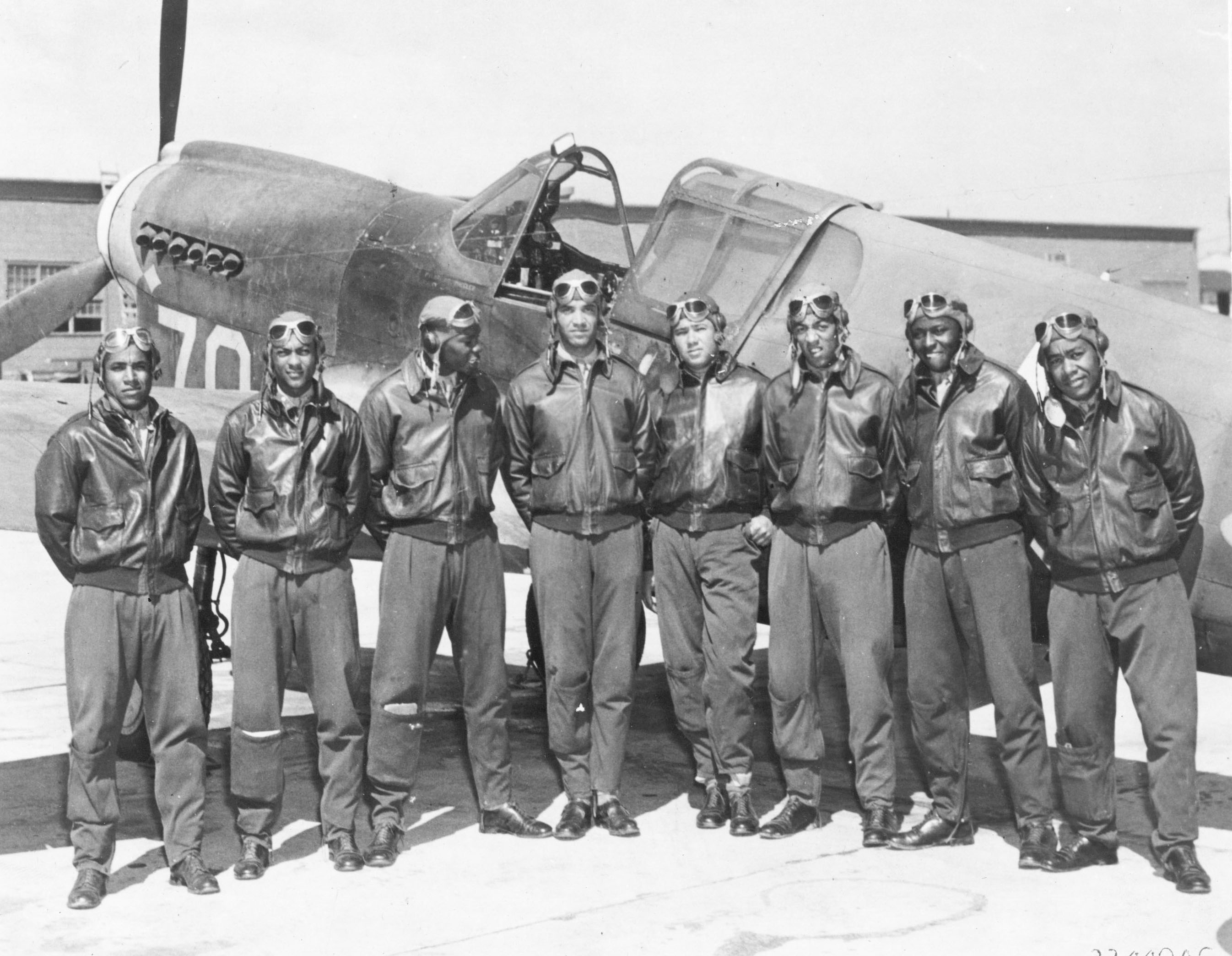 Eight Tuskegee Airmen in front of a P-40. ( Image via Wikipedia)