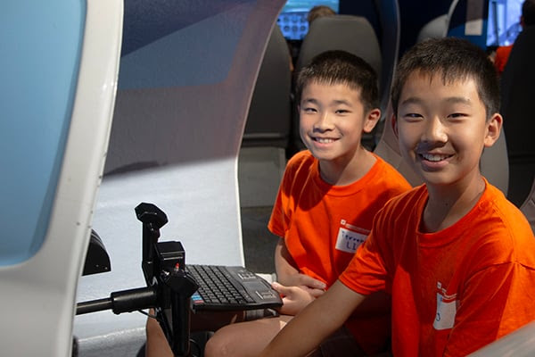 Two ACE campers enjoy a flight simulator at the Museum during their camp experience. Sean Mobley The Museum of Flight