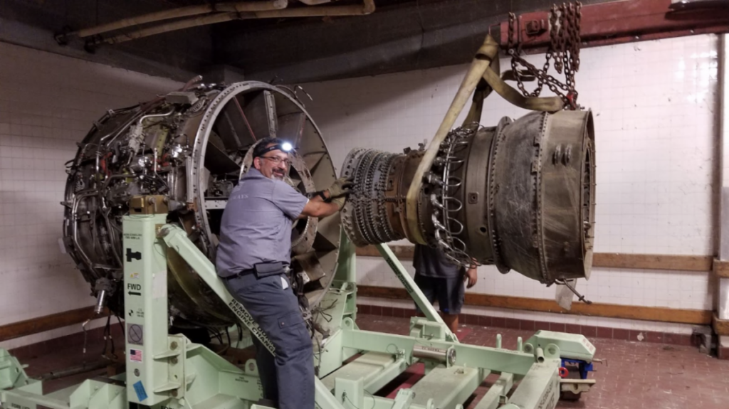 US Airways mechanic Paul Sullivan works to reattach the compressor and turbine section of the left engine to the fan frame