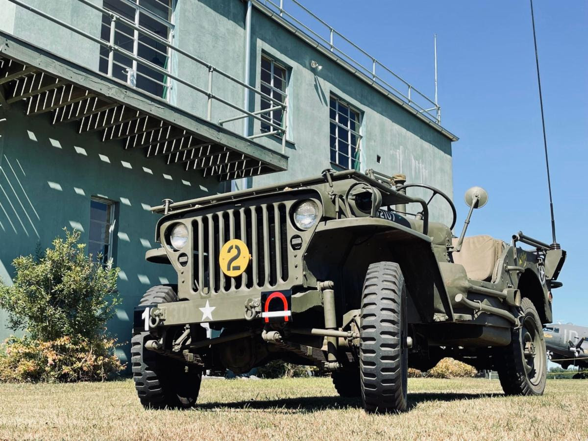 A WWII U.S. Army jeep standing beside the RAF Goxhill control tower at the Military Aviation Museum in Pungo, Virginia.
