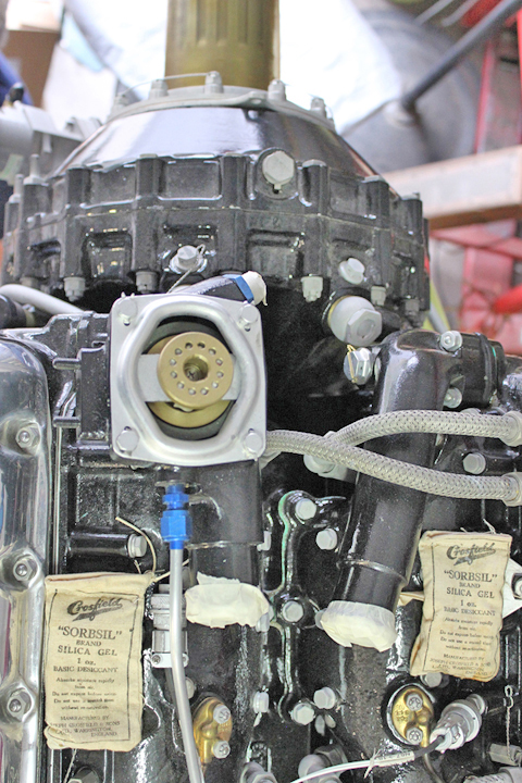 The forward section of a Merlin engine showing two of the water necks in position (note the plastic-capped black tubes at the lower section in between the two silica gel packs. (photo via Tom Reilly)